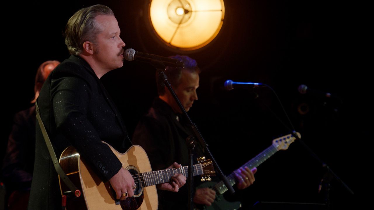 three men playing music and singing